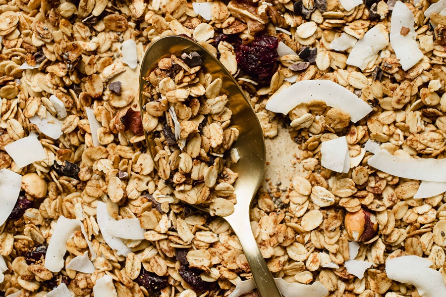 Easy Vegan Granola Recipe Close Up of Granola on a Baking Sheet with a Spoon