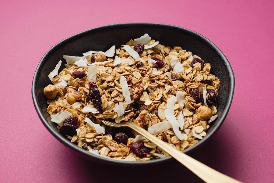 Easy Vegan Granola Recipe a Black Bowl of Granola with a Spoon