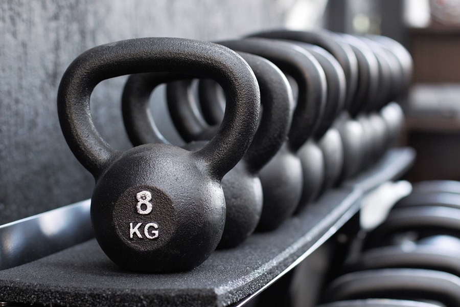 Kettlebell Exercises You Should Do Each Day Close Up of a Row of 8 Pound Kettlebell Weights