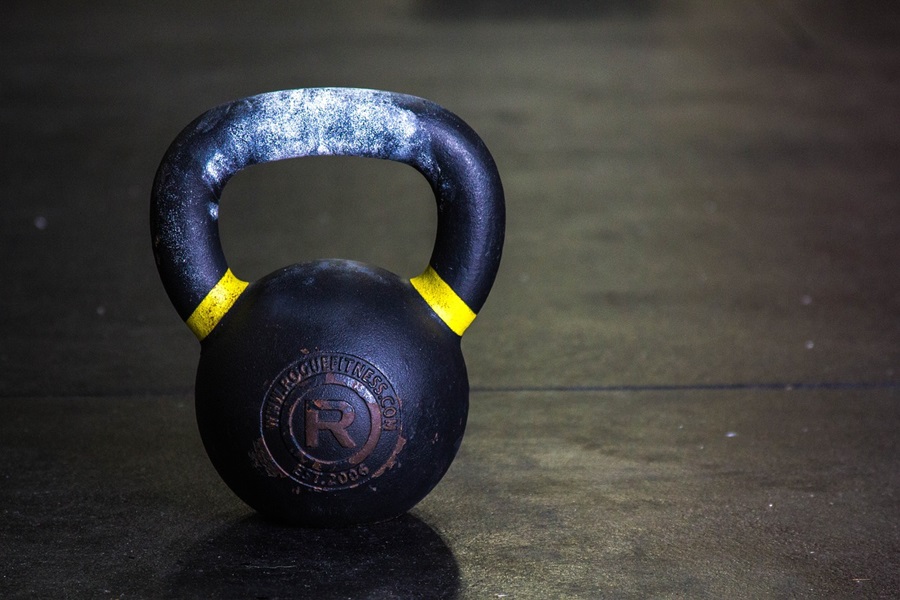 Kettlebell Exercises You Should Do Each Day Close Up of a Kettlebell on a Wood Surface