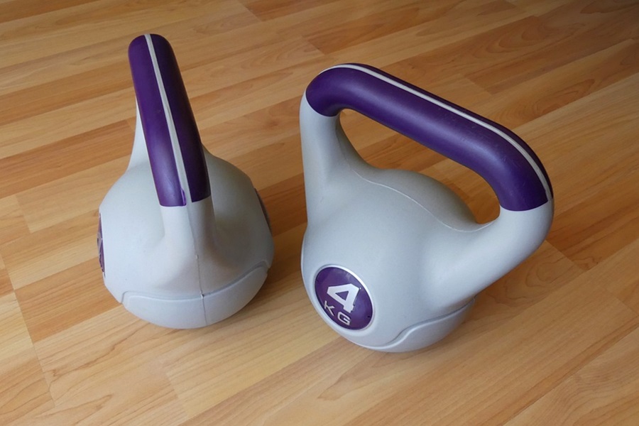Kettlebell Exercises You Should Do Each Day Close Up of Purple Kettlebell 4 Pound Weights on a Wood Floor
