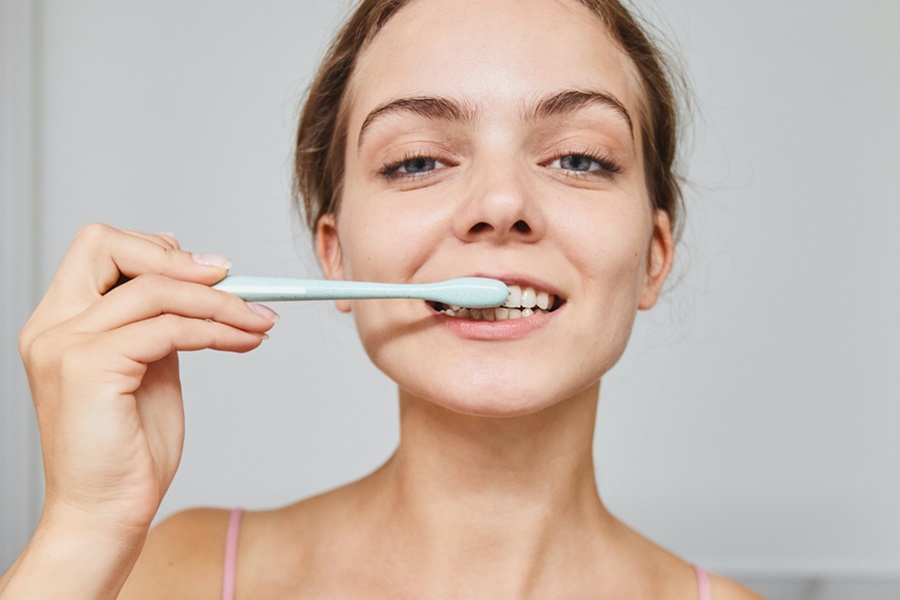 Exercises to Do While Brushing Your Teeth a Woman Looking Directly at The Camera While Brushing Her Teeth