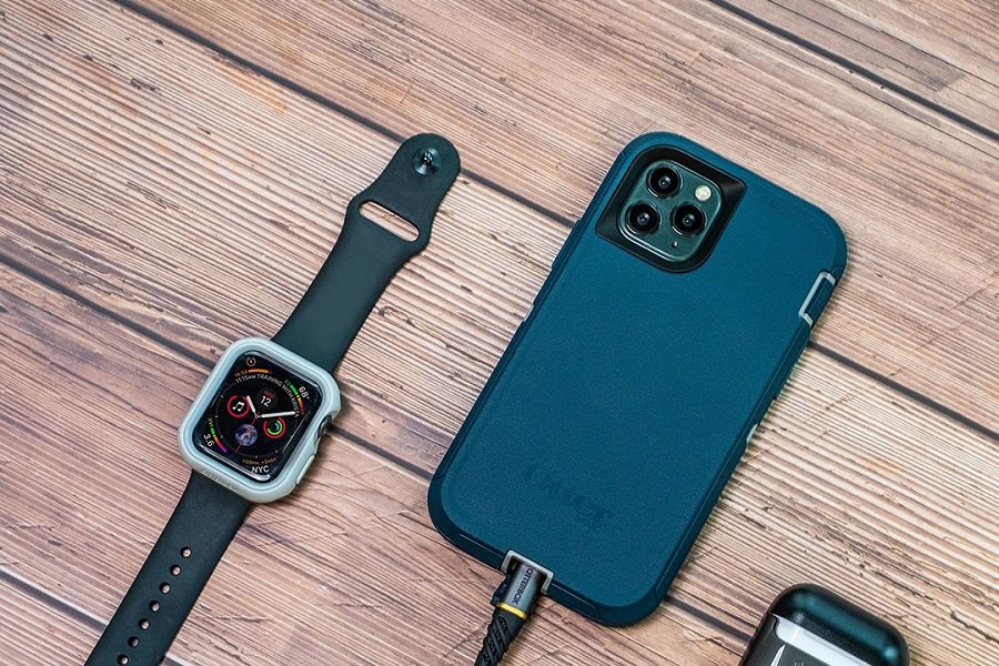 Otterbox Defender Pro Vs Defender Overhead View of a Defender Phone Case Next to a Smart Watch and Earbuds