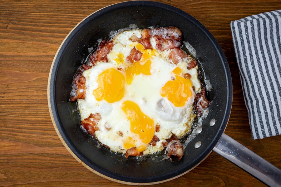 Keto Carb Limit vs Low Carb Limit a Pan with Eggs and Bacon Cooking Inside