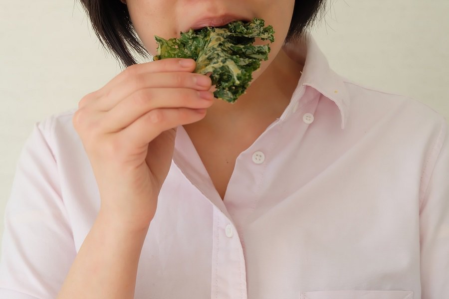 Low Sugar Snacks for a Low Carb Diet Close Up of a Woman Eating a Kale Chip