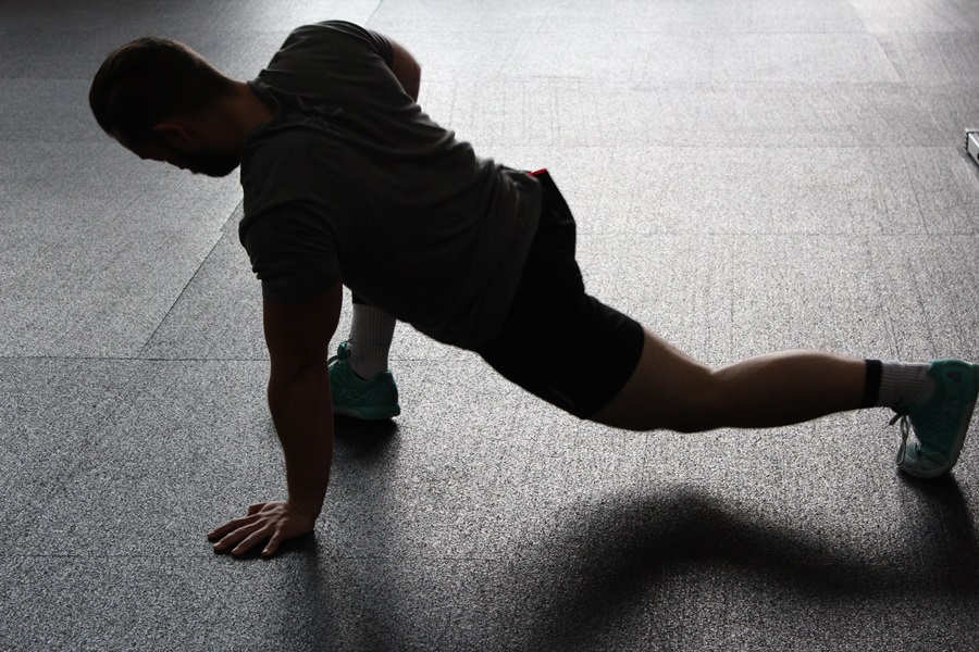 Transform 20 Workout FAQ a Man Wearing Workout Clothes Stretching in a Studio