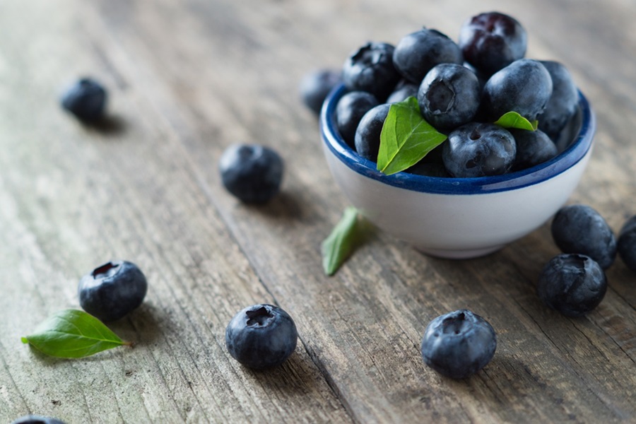 What is a Pegan Diet Close Up of a Small Bowl of Blueberries on a Wooden Table