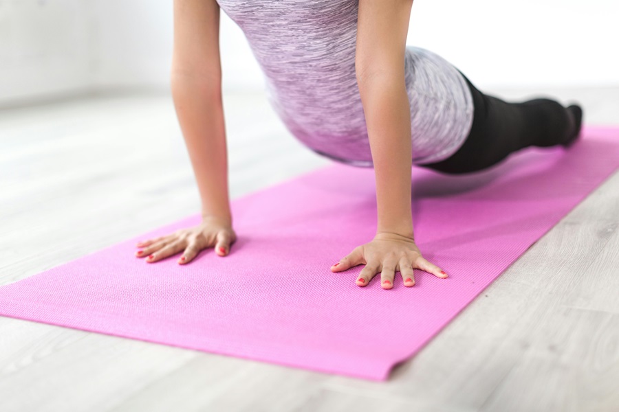 Transform 20 Week 5 Workouts and Tips a Woman Doing Yoga on a Pink Yoga Mat in a Room