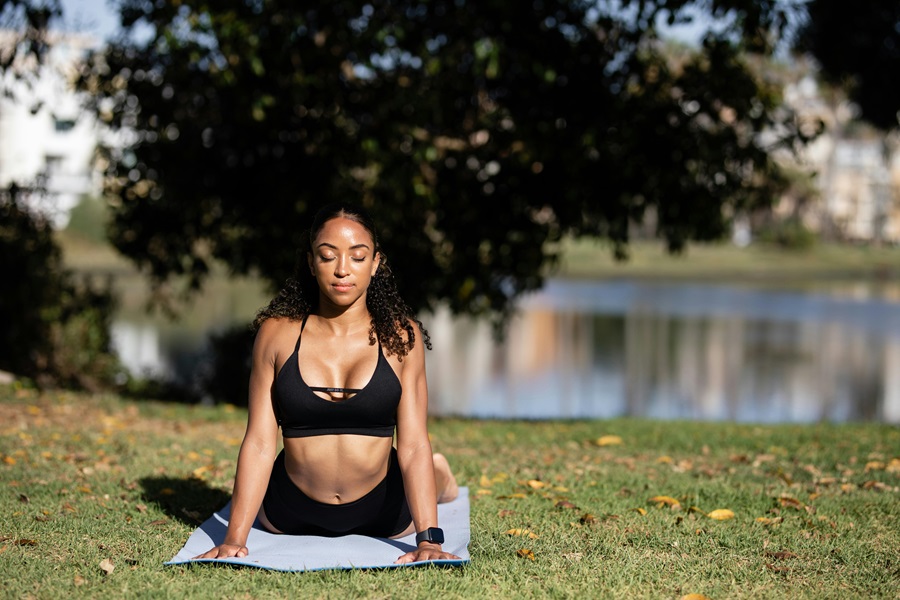 Transform 20 Week 5 Workouts and Tips a Woman Stretching in a Park Before a Workout