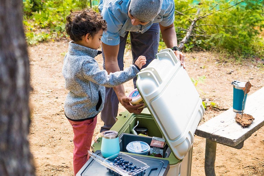 Otterbox Trooper Coolers Features and Review a Father and Son Reaching into a Cooler at a Camp Site