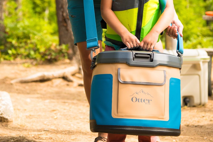 Otterbox Trooper Coolers Features and Review a Young Child Holding an Otterbox Cooler While Walking in a Forest