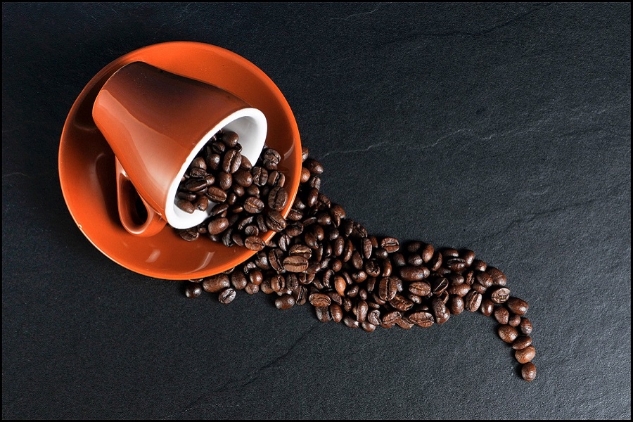 Intermittent Fasting Coffee Recipes a Red Coffee Cup Spilt Over with Coffee Beans Coming from Inside