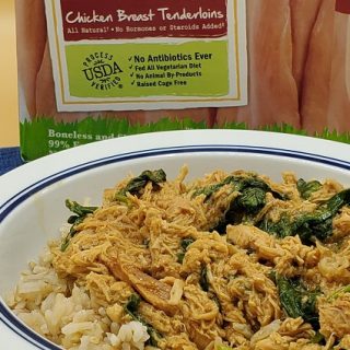 Crock-Pot Spicy Chicken Bowl Recipe with Spinach Angled View of a Bowl of Food with Raw Chicken in the Background