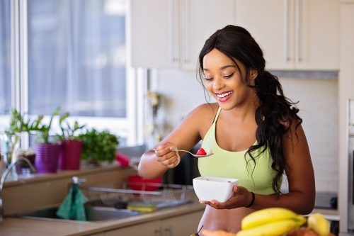 Intermittent Fasting Tips for Success a Woman Eating Oats with Fresh Fruit