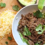Low Carb Crock Pot Beef Barbacoa Overhead View of Beef in a Bowl with Cilantro and Shredded Cheese