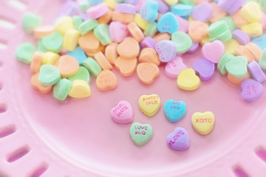 Valentine's Day Margarita Recipes Close Up of Heart-Shaped Candies with Loving Phrases on Them