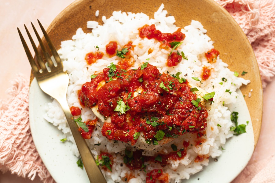 Salsa Chicken and Rice Recipe Overhead of a Plate of White Rice with Salsa Chicken on Top and a Fork