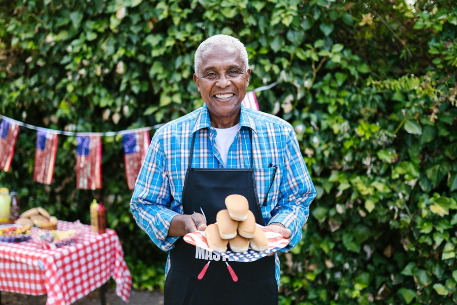 Red White and Blue Margarita Recipes a Elderly Man Wearing an Apron, Standing Outside Holding a Plate of Hot Dog Buns