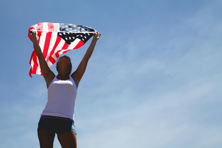 Red White and Blue Margarita Recipes a Woman Standing Outside Holding an American Flag Above Her Head