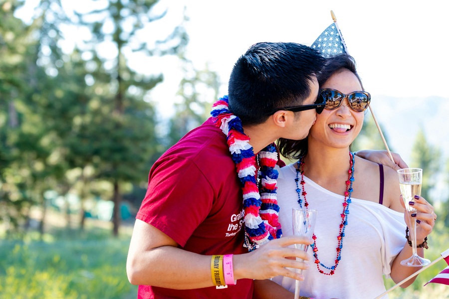 Red White and Blue Margarita Recipes a Couple Standing Together Outside Wearing American Flag Colors and Holding a Small American Flag