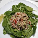 Overhead View of Mediterranean Tuna Salad on a Bed of Spinach.