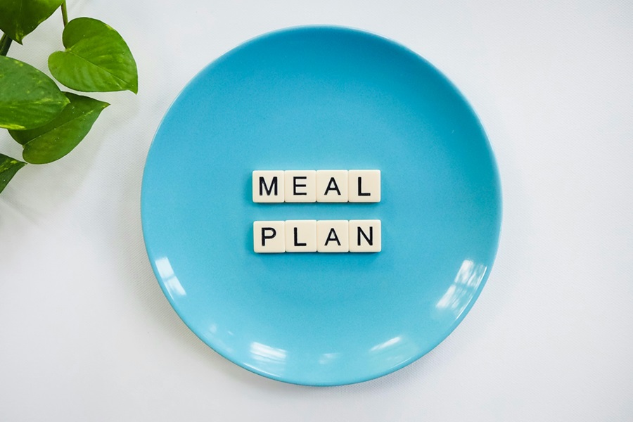 Beachbody 2B Mindset FAQ Close Up of a Blue Plate with Letter Tiles on it Spelling Out Meal Plan