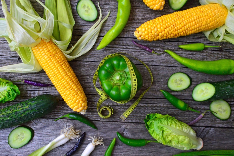 Low Carb Lunch Ideas Corn Cobs and Peppers with a Measuring Tape Wrapped Around Them on a Wooden Surface