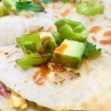 Healthy Breakfast Quesadilla Recipe Finished Quesadilla on a Cutting Board Close Up with Avocado