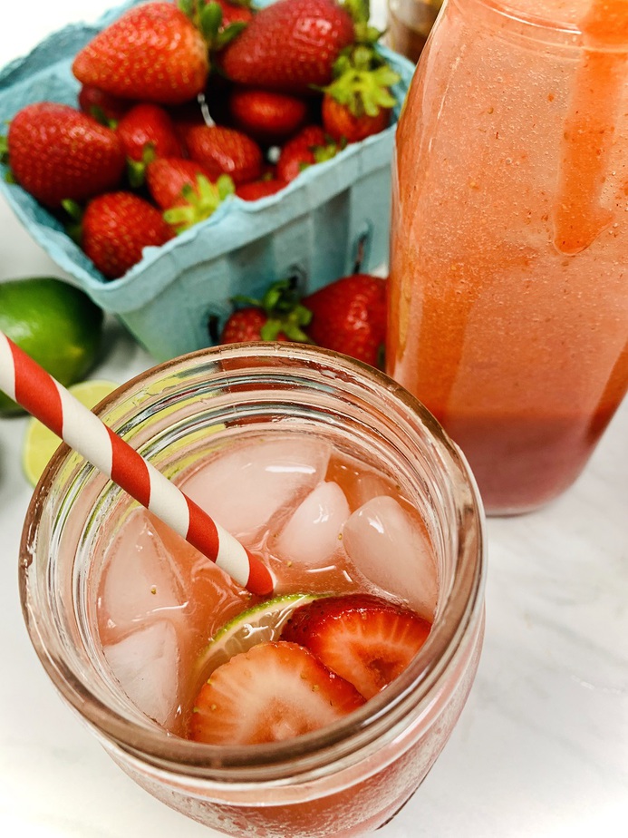 Strawberry Margarita Recipe Overhead View of Margarita in a Mason Jar Next to a Basket of Strawberries