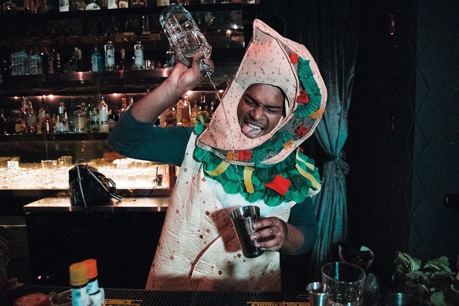 Halloween Cocktails a Man Dressed in a Taco Costume Pouring Alcohol into a Shaker Cup