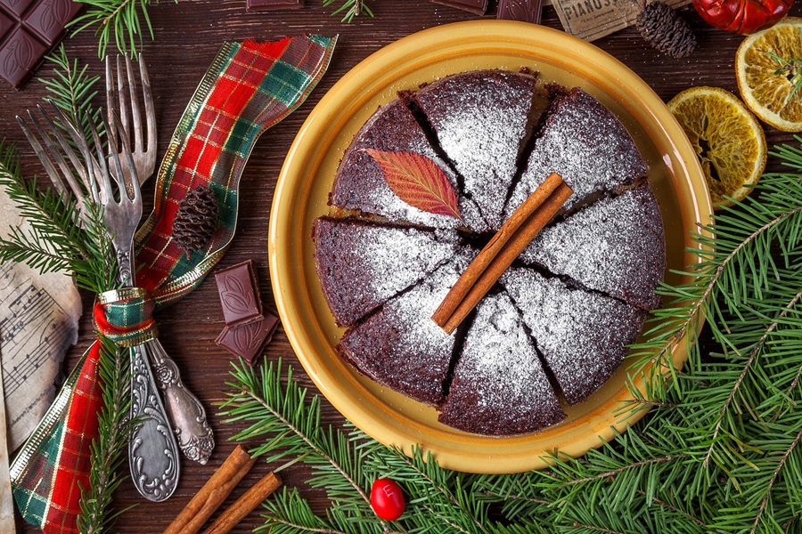 Easy Crockpot Thanksgiving Desserts Overhead View of a Chocolate Cake Dusted with Powder Sugar and Surrounded with Holiday Decor