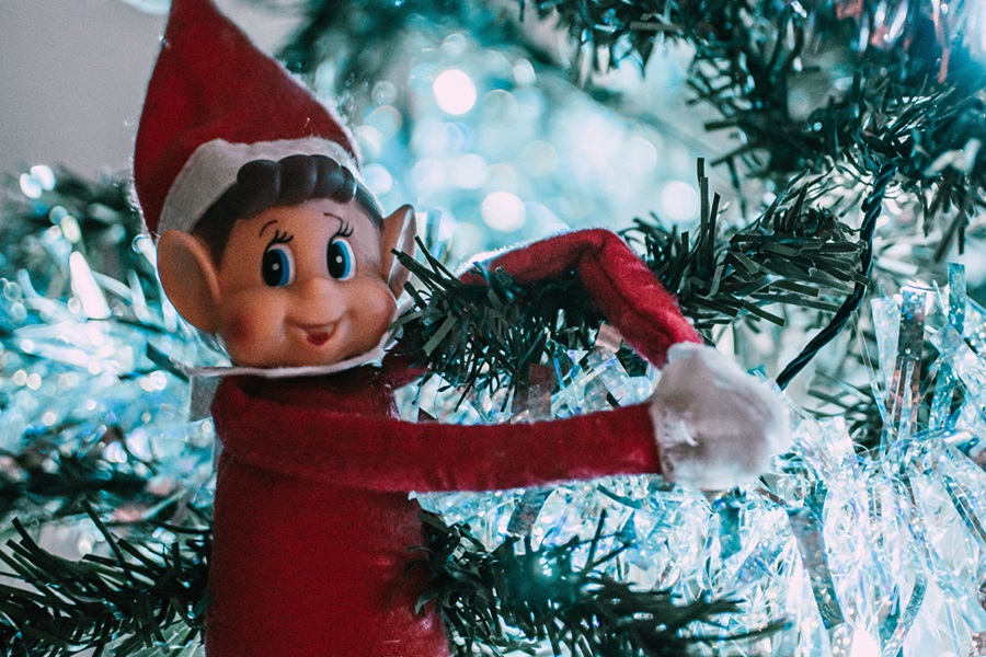 Quick Tips for when your Elf on the Shelf Didn't Move Close Up of an Elf Hugging The Top of a Christmas Tree