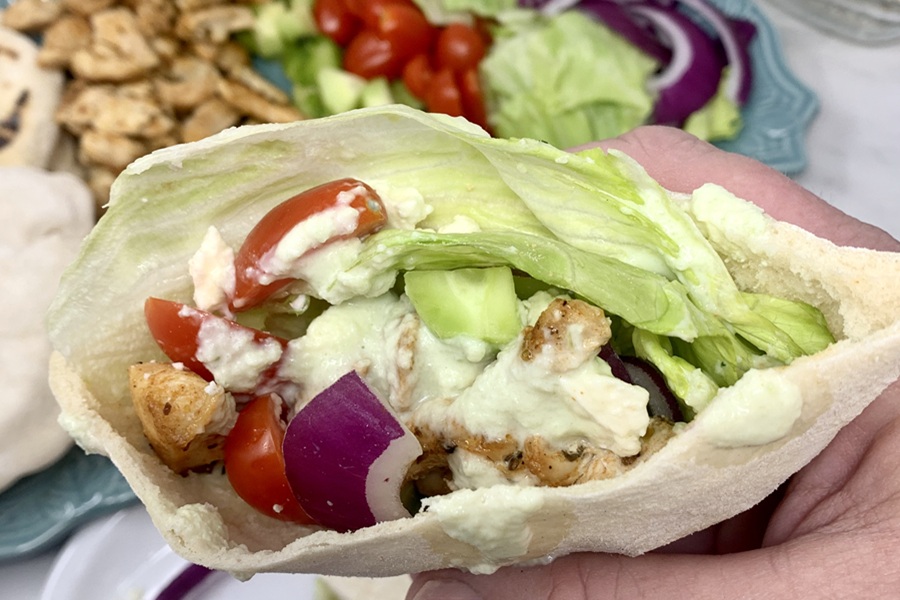 Chicken and Tzatziki in Pita Pockets Close Up of Pockets Being Held by a Person's Hand