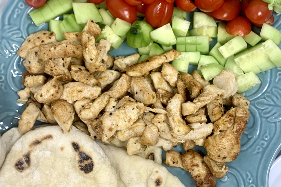 Chicken and Tzatziki in Pita Pockets Close Up of Chicken, Pita Bread, Cucumber, Tomatoes and Lettuce on a Serving Platter in Neat Rows