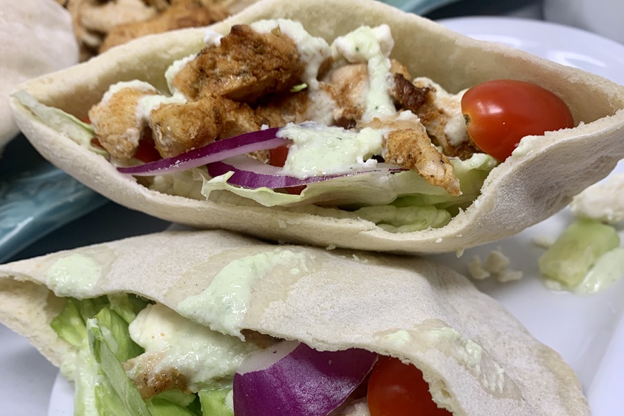 Close Up of Chicken and Tzatziki in Pita Pockets on a Plate