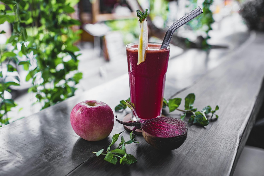 Jillian Michaels Detox Close Up of a Detox Smoothie with a Beet Cut in Half and an Apple with Some Spinach
