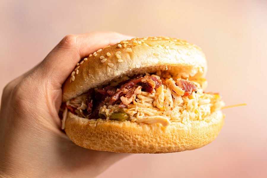 Crockpot Chicken and Bacon Keto Close Up of a Chicken and Bacon Sandich in a Person's Hand