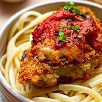 Best Panko Chicken Parmesan Recipe Close Up of Chicken Parmesan on Top of Spaghetti in a White Bowl