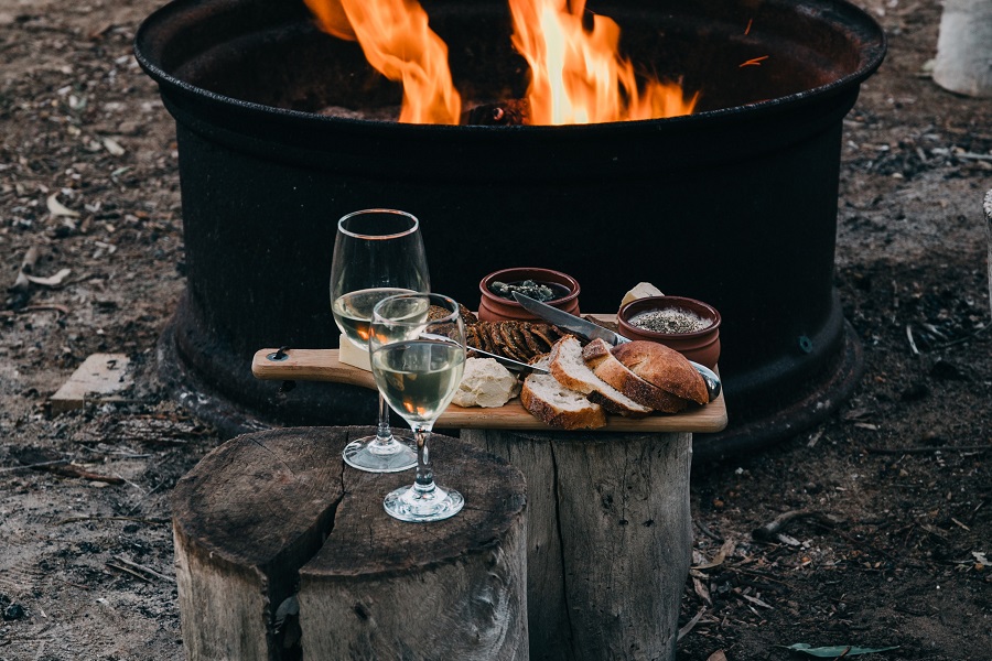 Easy Appetizers Wine Glasses and a Charcuterie Board on a Wooden Log Next to a Campfire