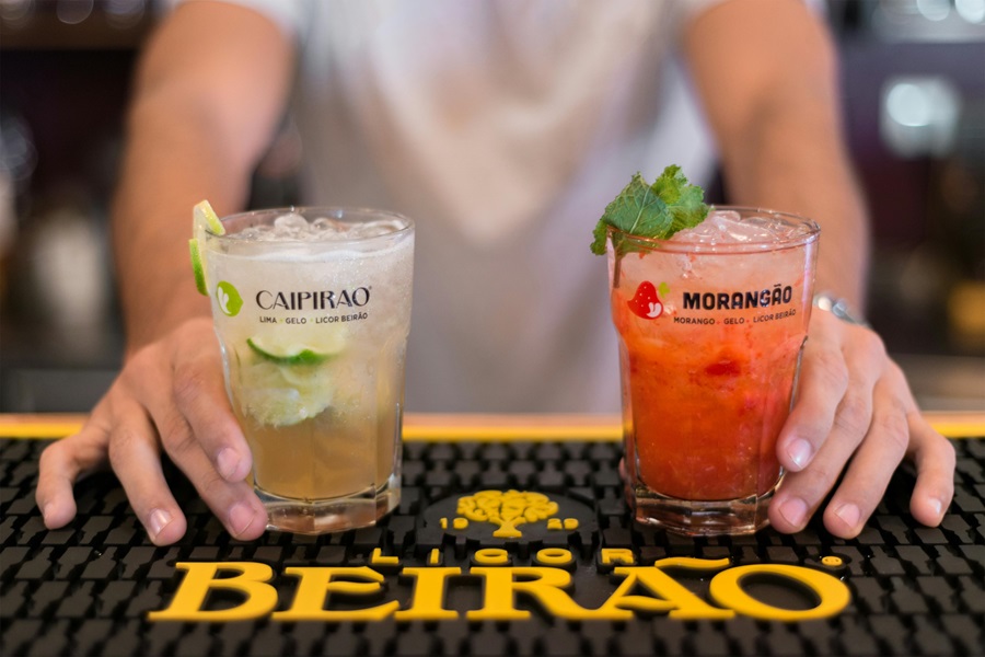 Totally Tasty Tequila Drinks that are not All Margaritas a Bartender Holding Two Cocktails on a Bar Top