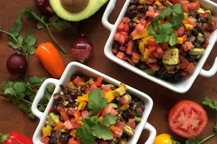 2B Mindset Meal Plan Ideas for Lunch Overhead View of Two Small Bowls Filled with Cowboy Caviar Surrounded by Ingredients Like Avocados, Peppers, Onions, and Tomatoes