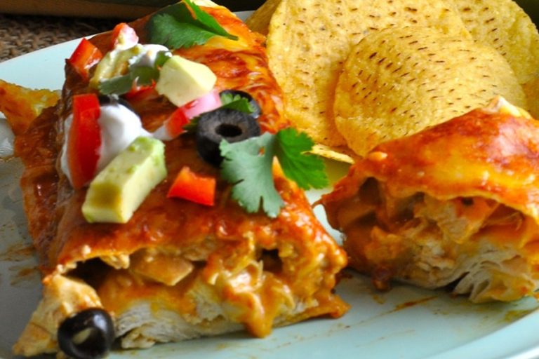 Easy Chicken Enchiladas Recipe Close Up of an Enchilada Cut in Half on a Plate with Tortilla Chips