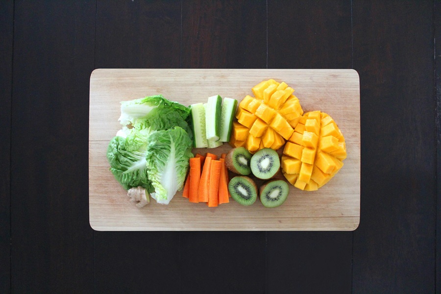 What Can You Eat on a Pegan Diet a Cutting Board with Lettuce, Carrots, Zucchini, Squash, and Kiwi