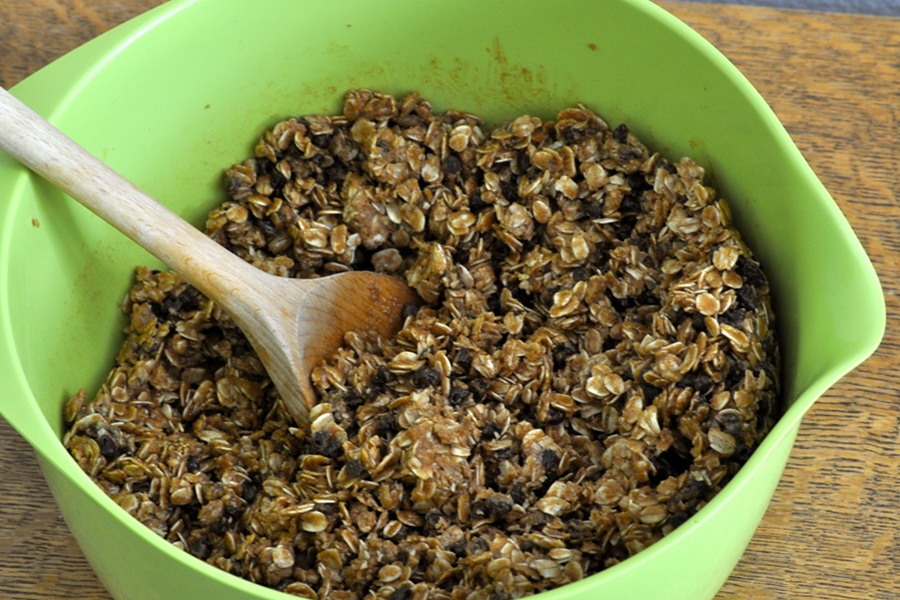 Peanut Butter Oatmeal Balls Mixed Peanut Butter, Oats, and Chocolate Chips in a Green Mixing Bowl with a Wooden Spoon