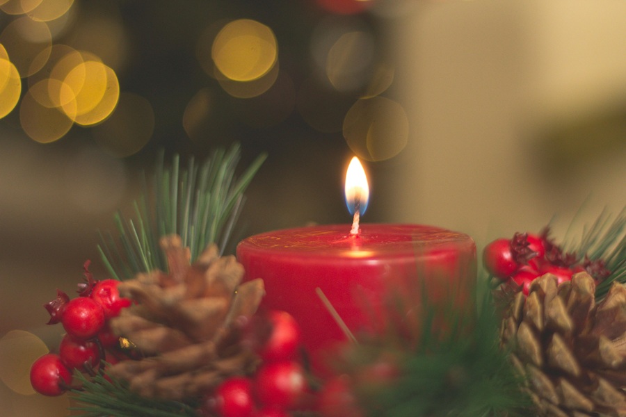 Cranberry Margarita Recipes Close Up of a Red Candle Surrounded with Pinecones and Decorative Pine Tree Branches