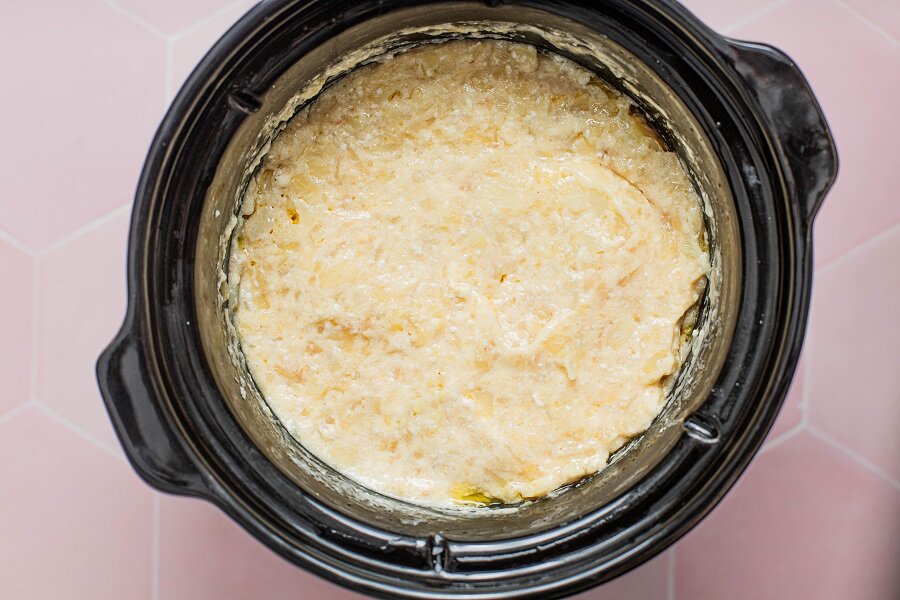 Crockpot Cheesy Hashbrowns Overhead View of a Crockpot with Cheese Topped Potatoes