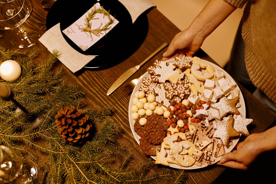 Dairy Free Holiday Cookies Overhead of a Woman Putting a Serving Platter of Cookies on a Table