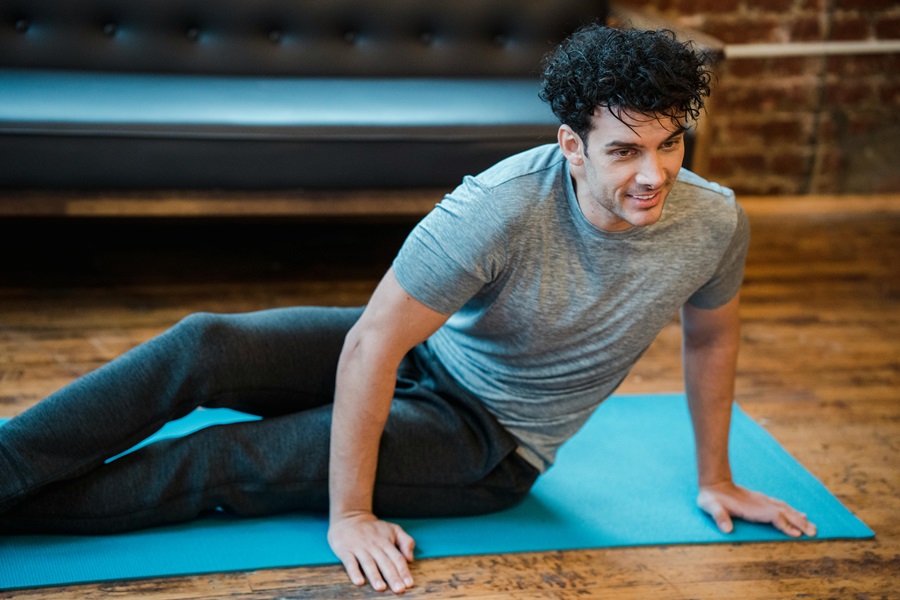 10 Minute At Home Workouts for Abs a Man Doing an Ab Workout on a Blue Yoga Mat in a Room