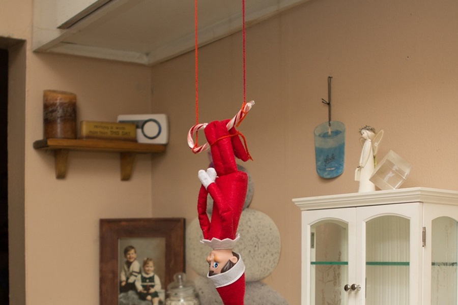 Easy Elf on The Shelf Ideas an Elf Hanging Upside Down From Kitchen Cabinets