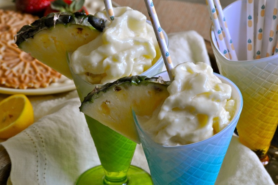 Make at Home Dole Whip Recipe Two Glasses of Dole Whip Each Garnished with a Straw and a Pineapple Wedge